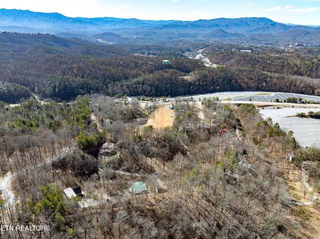 birds eye view of property with a mountain view and a wooded view