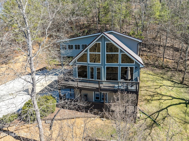 exterior space featuring a deck and a wooded view