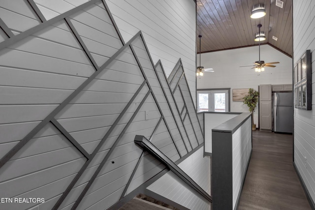 stairs with wood ceiling, high vaulted ceiling, and wood finished floors