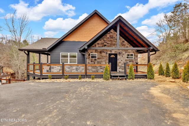 chalet / cabin with stone siding and a wooden deck