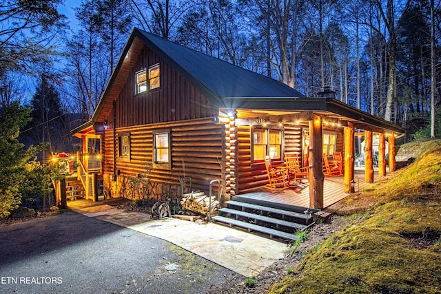 log cabin with log exterior and a porch