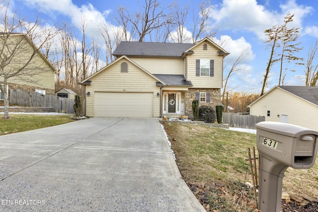 traditional home featuring driveway, stone siding, an attached garage, fence, and a front yard