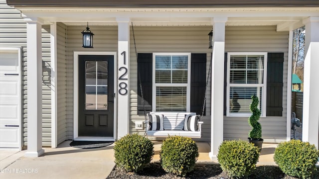 entrance to property featuring a garage and a porch