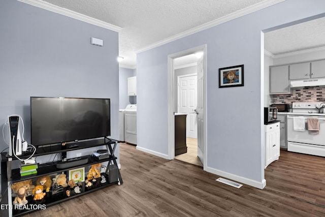 living room featuring washer / dryer, crown molding, visible vents, and dark wood-style flooring