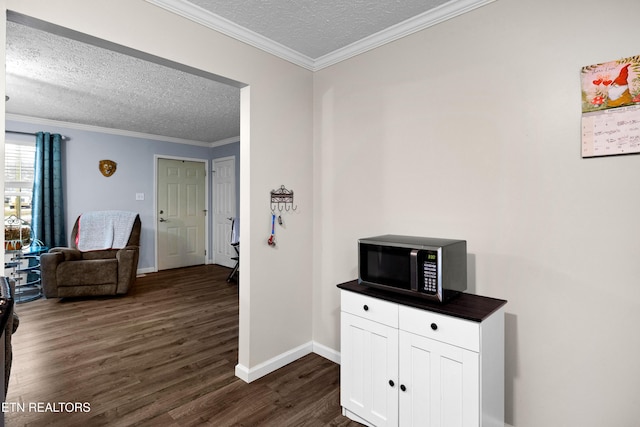 corridor featuring ornamental molding, dark wood-style flooring, a textured ceiling, and baseboards