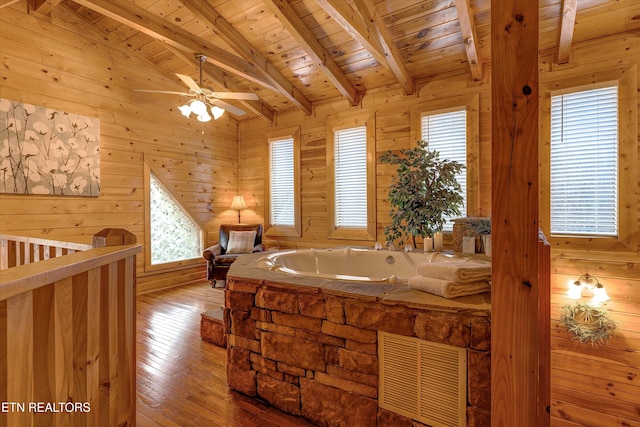 bathroom with beam ceiling, visible vents, wooden ceiling, and wooden walls