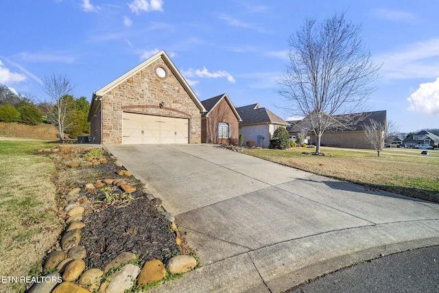 view of front of home with driveway, stone siding, a garage, and a front lawn