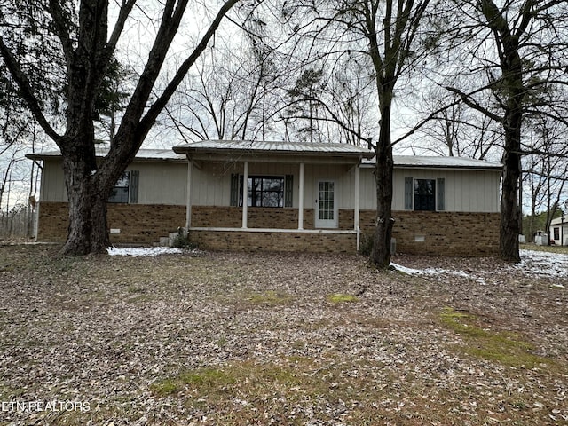 ranch-style house with crawl space, brick siding, and metal roof