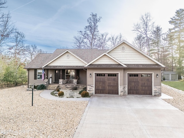 view of front of home with an attached garage, stone siding, covered porch, and concrete driveway