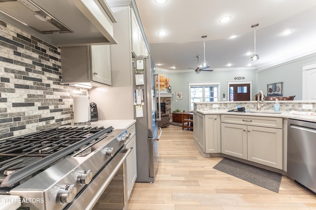 kitchen featuring decorative backsplash, custom range hood, appliances with stainless steel finishes, ornamental molding, and a sink