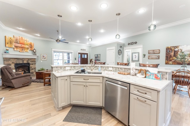 kitchen featuring an island with sink, open floor plan, stainless steel dishwasher, pendant lighting, and a sink