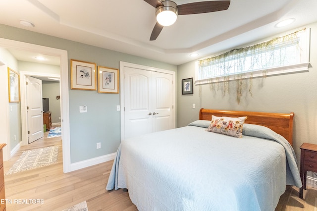 bedroom featuring a closet, recessed lighting, light wood-style flooring, and baseboards