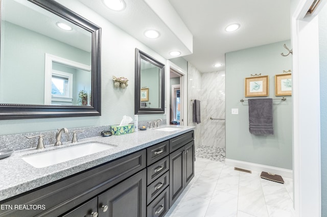 bathroom featuring marble finish floor, a sink, a marble finish shower, and double vanity