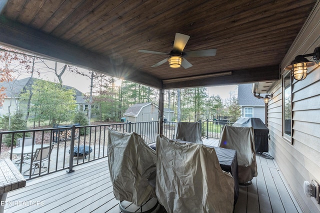 wooden deck with an outbuilding, ceiling fan, and a shed