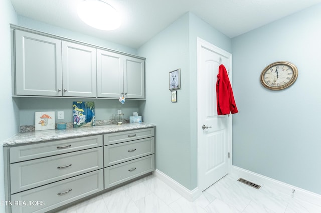 interior space featuring marble finish floor, baseboards, visible vents, and vanity