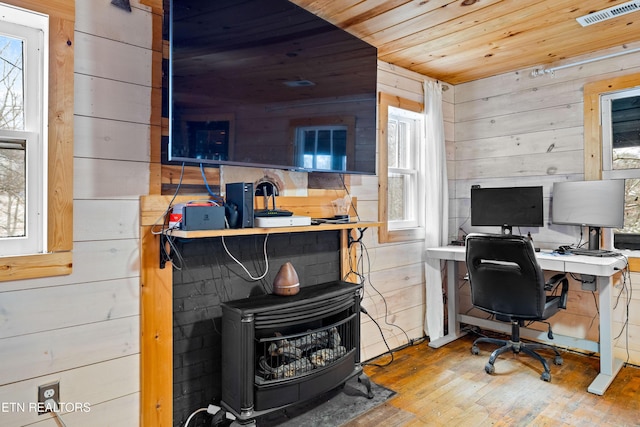 office space featuring wood walls, wood ceiling, visible vents, and wood finished floors