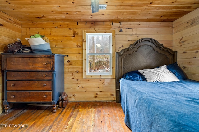 bedroom featuring wood ceiling, wooden walls, and wood finished floors