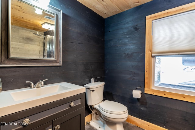 half bathroom featuring wood walls, vanity, and toilet