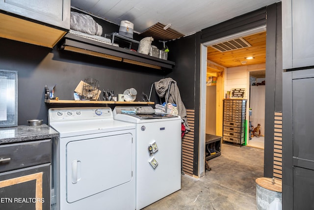 washroom with washing machine and clothes dryer and visible vents