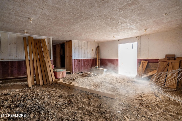 miscellaneous room featuring a wainscoted wall and wood walls