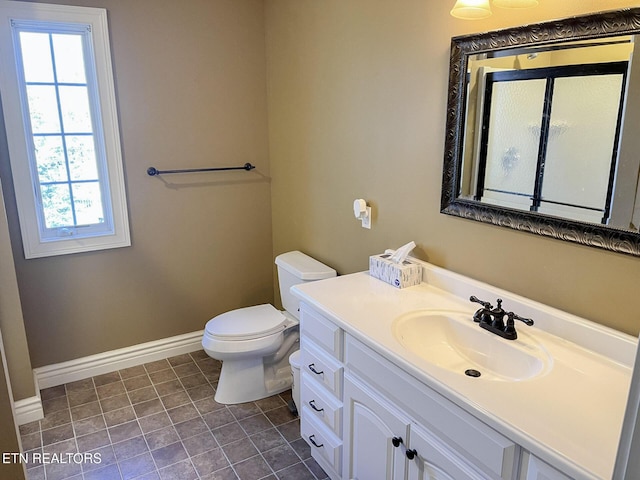 bathroom featuring toilet, baseboards, and vanity