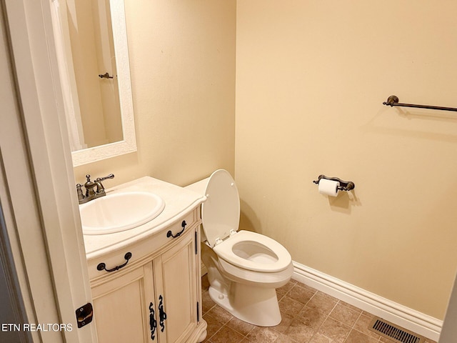 bathroom with toilet, baseboards, visible vents, and vanity