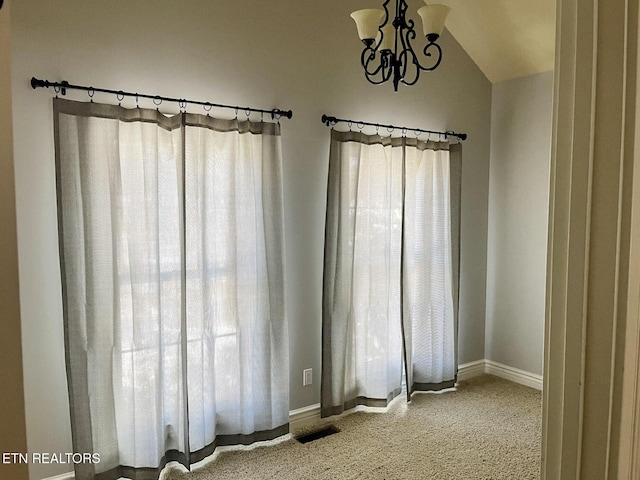 unfurnished room featuring a chandelier, lofted ceiling, visible vents, and plenty of natural light