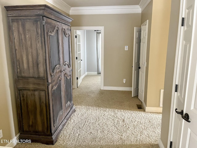 hall featuring carpet, visible vents, ornamental molding, and baseboards