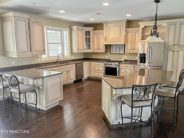 kitchen featuring premium appliances, hanging light fixtures, custom exhaust hood, and a breakfast bar area