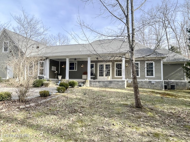 view of front facade featuring covered porch, a shingled roof, and central AC unit