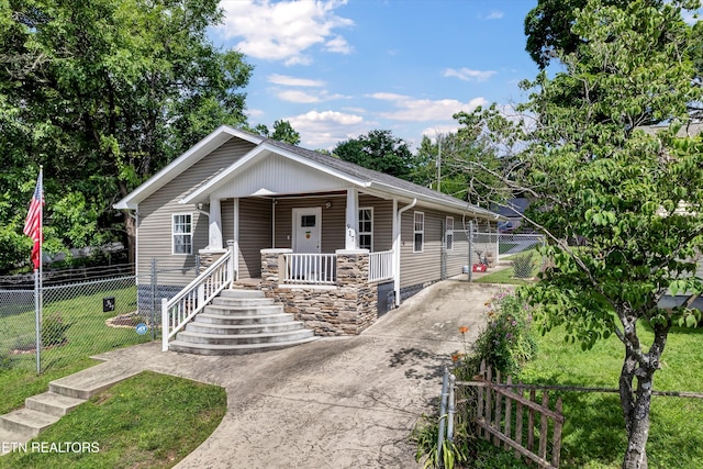 view of front facade featuring concrete driveway, a porch, a front lawn, and fence