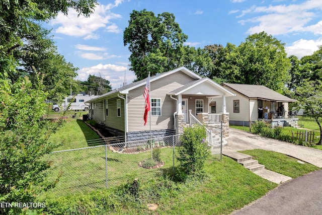 view of front of property with driveway, a porch, a front yard, and fence