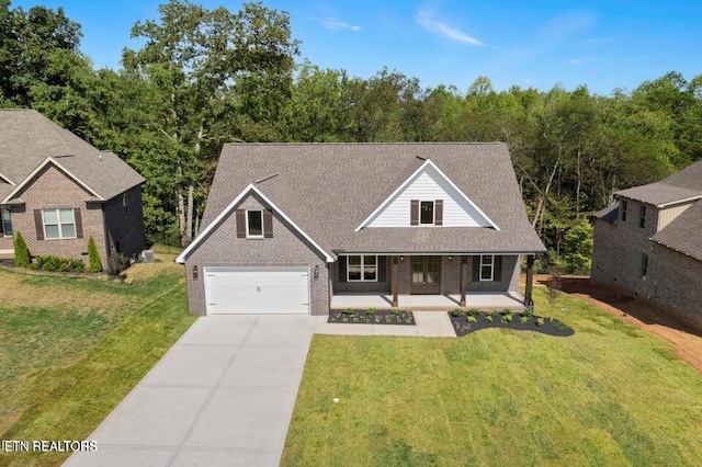 view of front of property with brick siding, a porch, concrete driveway, a front yard, and a garage