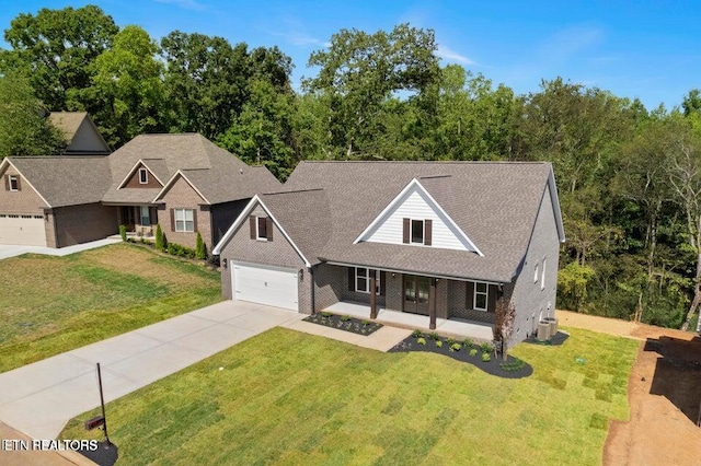 view of front facade featuring covered porch, a garage, brick siding, driveway, and a front lawn