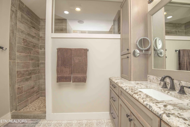 bathroom featuring recessed lighting, walk in shower, vanity, and baseboards