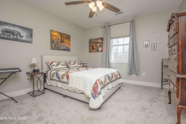 carpeted bedroom featuring a ceiling fan, visible vents, and baseboards