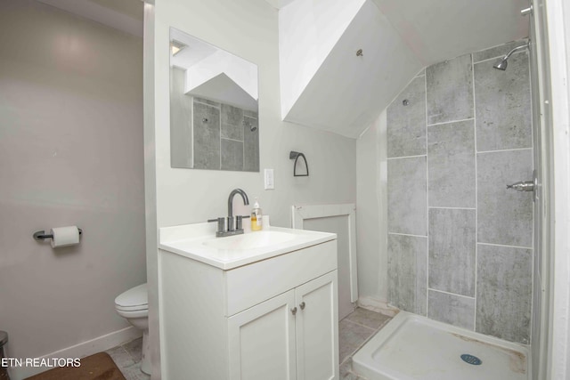 full bath featuring toilet, lofted ceiling, a tile shower, and vanity