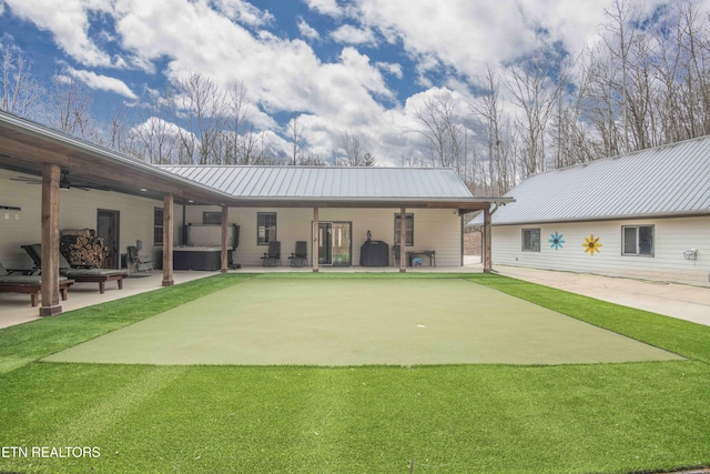 rear view of property with a standing seam roof, a patio area, and metal roof