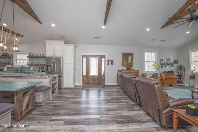 kitchen with lofted ceiling, dark wood-style flooring, white cabinets, open floor plan, and stainless steel refrigerator with ice dispenser