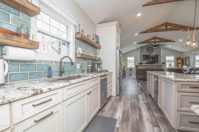 kitchen featuring open shelves, appliances with stainless steel finishes, open floor plan, a sink, and vaulted ceiling