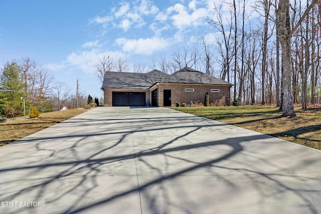 view of front of house featuring a garage, concrete driveway, brick siding, and a front yard