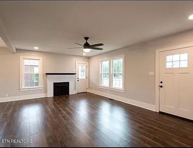 unfurnished living room with dark wood-type flooring, a fireplace, recessed lighting, and baseboards