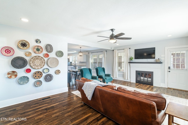 living room featuring dark wood-style floors, recessed lighting, a brick fireplace, ceiling fan, and baseboards