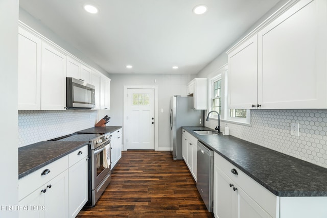 kitchen featuring appliances with stainless steel finishes, dark countertops, and white cabinetry