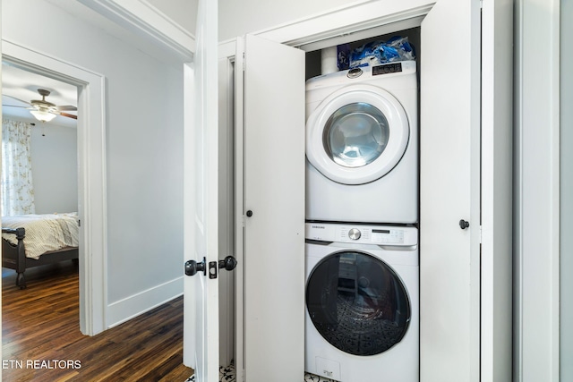 washroom featuring dark wood-type flooring, stacked washer / dryer, and laundry area