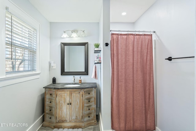 bathroom with a shower with curtain, vanity, and baseboards