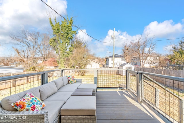 wooden terrace with an outbuilding, outdoor lounge area, fence, and a storage shed