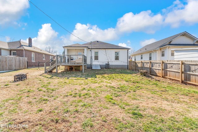 rear view of house with a yard, a fenced backyard, stairs, and a wooden deck