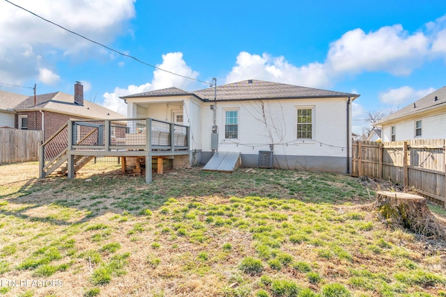 rear view of property with a yard, central AC unit, a fenced backyard, and a wooden deck