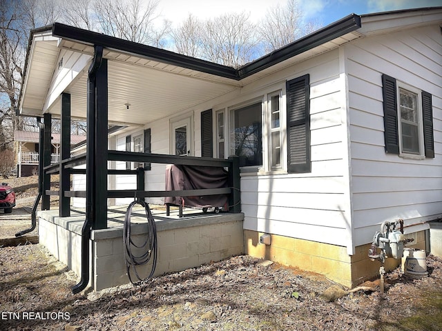 view of side of property featuring covered porch